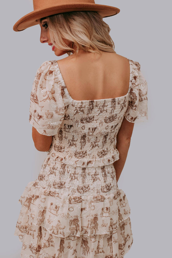 Woman wearing a floral dress and brown hat against a gray background